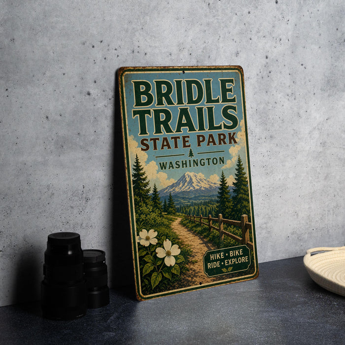 A vintage-style metal sign for Bridle Trails State Park in Washington, featuring a scenic mountain landscape and a path leading through the woods.