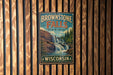 A vintage metal sign for Brownstone Falls State Park in Wisconsin, featuring a scenic image of the waterfall surrounded by trees and rocks.