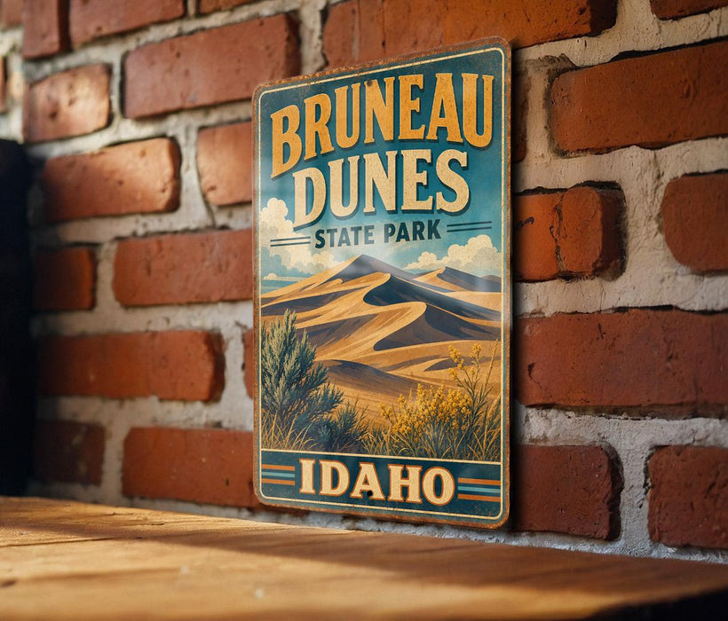 A vintage-style metal sign for Brunette Dunes State Park in Idaho, featuring a desert landscape with mountains and desert vegetation.