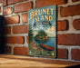 A vintage-style metal sign for Brunet Island State Park in Wisconsin, featuring a scenic illustration of a lake, pine trees, and a canoe.
