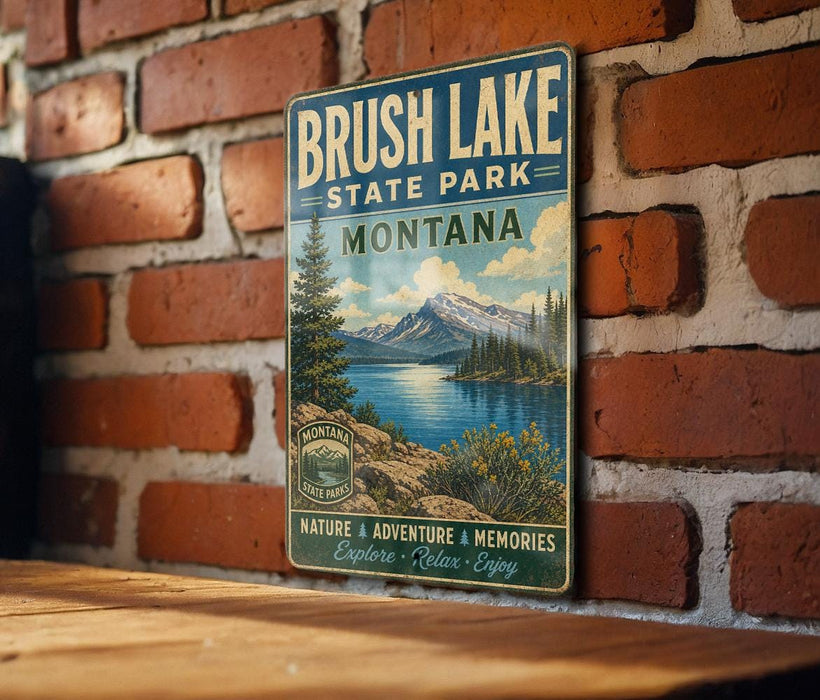 A vintage metal sign for Brush Lake State Park in Montana, featuring a scenic landscape with mountains, trees, and a lake.