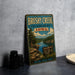 A vintage-style sign for Brushy Creek State Recreation Area in Iowa, featuring a scenic landscape with a river, trees, and a sign for outdoor activities.