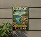A vintage-style sign for Buck's Pocket State Park in Alabama, featuring a scenic landscape with a lake, cliffs, and flowers.