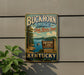 A vintage metal sign for Buckhorn Lake State Resort Park in Kentucky, featuring a scenic lake landscape with a boat and trees.