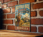 A vintage-style sign for Buffalo Bill Ranch, a state historical park in Nebraska, featuring an illustration of a cowboy in a cowboy hat and a ranch house.