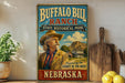 A vintage-style sign for Buffalo Bill Ranch, a state historical park in Nebraska, featuring an illustration of a man in cowboy attire and a scenic landscape.