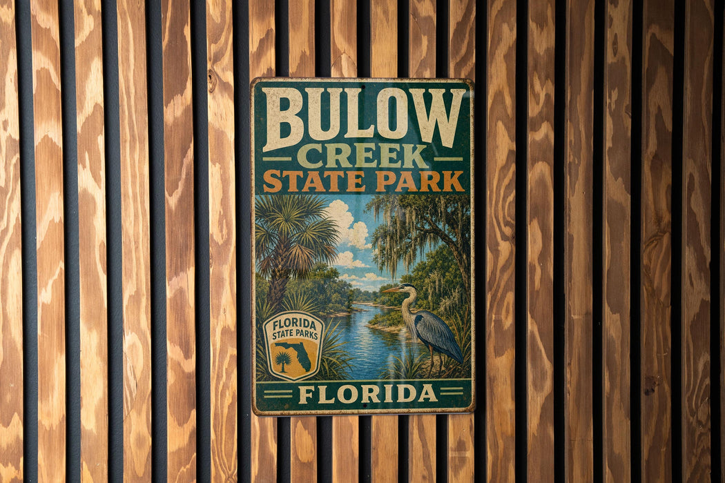 A vintage metal sign for Bulow Creek State Park in Florida, featuring a scenic illustration of a bird and palm trees.