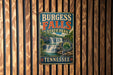 A vintage metal sign forBURGESS FALLS State Park in Tennessee, featuring a waterfall and surrounded by trees.