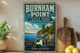 A vintage-style sign for Burnham Point State Park in New York, featuring a scenic landscape with a lake, mountains, and pine trees.