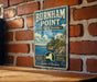 A vintage metal sign for Burnham Point State Park, featuring a scenic illustration of the park and its surrounding landscape.