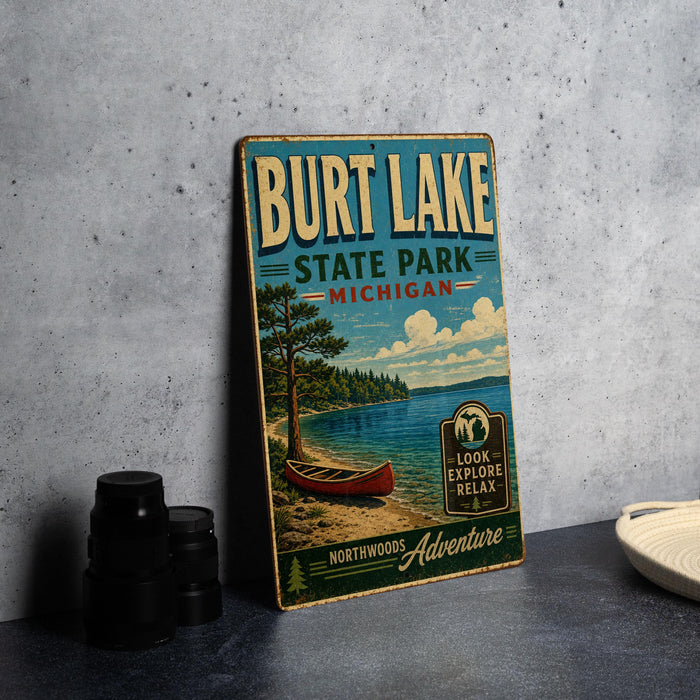 A vintage-style metal sign for Burt Lake State Park in Michigan, featuring a scenic image of a lake, canoe, and forest.