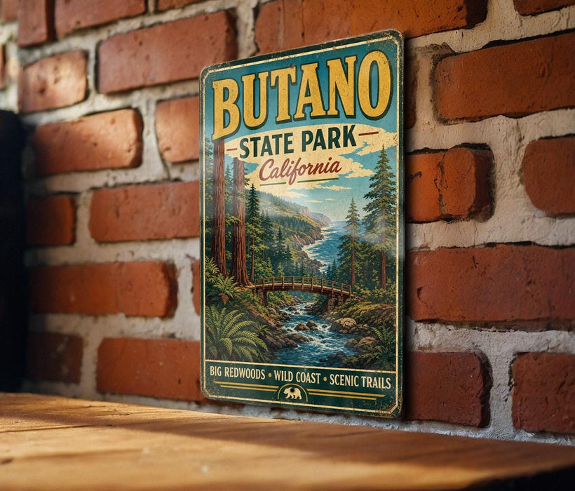 A vintage-style metal sign for Butano State Park in California, featuring a scenic landscape with a river, bridge, and trees.