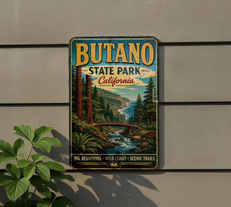 A vintage-style metal sign for Butano State Park, California, featuring a scenic landscape with a river, mountains, and trees.