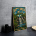 A vintage-style sign for Buttermilk Falls State Park, featuring a waterfall and lush greenery, is displayed on a gray countertop.