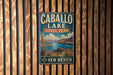 A vintage metal sign for Caballo Lake State Park in New Mexico, featuring a scenic landscape with mountains, a lake, and desert vegetation.