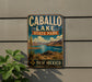 A vintage-style metal sign for Caballo Lake State Park in New Mexico, featuring a scenic landscape with mountains, a lake, and desert vegetation.