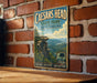 A vintage metal sign for Caesar's Head State Park in South Carolina, featuring a scenic mountain landscape with a cliff and a bridge.