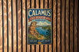 A vintage metal sign for Calamus State Recreation Area in Nebraska, featuring a scenic landscape with a river and mountains.