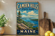 A vintage-style metal sign for Camden Hills State Park in Maine, featuring a scenic landscape with mountains, ocean, and a lake.