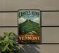 A vintage metal sign for Camel's Hump State Park, featuring a mountain landscape and the words "Beautiful Vermont" in a vintage style.