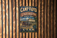 A vintage metal sign for Camp Floyd Stagecoach Inn in Stagecoach, Utah, featuring an illustration of a stagecoach and a historic building.
