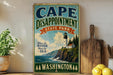 A vintage-style sign for Cape Disappointment State Park in Washington, featuring a lighthouse and a coastal landscape.