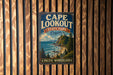 A vintage metal sign for Cape Lookout State Park in Oregon, featuring a scenic coastal landscape with a lighthouse and mountains in the background.