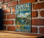 A vintage metal sign for the Capital Springs State Recreation Area in Wisconsin, featuring a scenic illustration of the state's natural beauty.