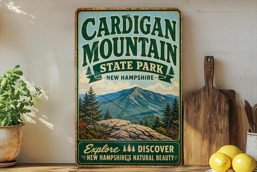 A vintage-style sign for Cardigan Mountain State Park in New Hampshire, featuring a scenic mountain landscape and the text "Explore, Discover, New Hampshire's Natural Beauty".