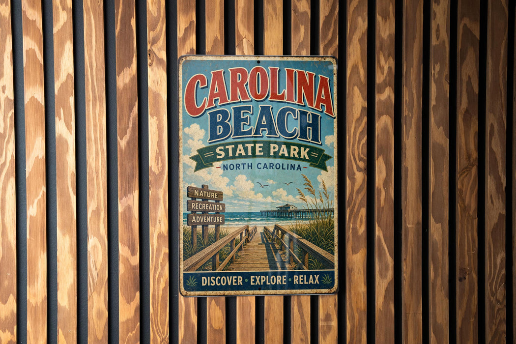 A vintage metal sign for Carolina Beach State Park, featuring a scenic beach and pier view, is displayed on a wooden wall.