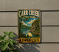 A vintage metal sign for Carr Creek State Park in Kentucky, featuring a scenic landscape with a lake and mountains.