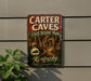 A vintage metal sign for Carter Caves State Resort Park in Kentucky, featuring an illustration of a cave system and the text "Kentucky Nature's Wonderland Awaits".