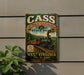 a vintage-style metal sign with a train and a scenic landscape, mounted on a wall.