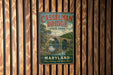 A vintage metal sign for Casselman Bridge State Park in Maryland, featuring a scenic illustration of the bridge and surrounding landscape.