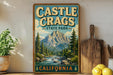A vintage-style metal sign for Castle Crags State Park in California, featuring a scenic mountain landscape with a river and pine trees.