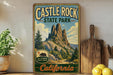 A vintage-style sign for Castle Rock State Park in California, featuring a mountain landscape with pine trees and a bear.