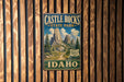 A vintage-style metal sign for Castle Rocks State Park in Idaho, featuring a scenic mountain landscape.