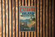 A vintage metal sign for Catawba Island State Park in Ohio, featuring a lighthouse and a beach scene.