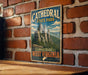 A vintage-style metal sign for Cathedral State Park in West Virginia, featuring a scenic illustration of the park's rock formations and mountains.