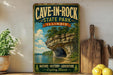 A vintage-style sign for Cave-in-Rock State Park in Illinois, featuring a scenic image of a rocky cliff with a lake below.