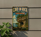 A vintage metal sign for Cave-in-Rock State Park in Illinois, featuring a scenic image of a rocky cliff with a lake below.