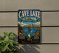 a vintage metal sign for Cave Lake State Park, Nevada, with a scenic mountain landscape and a lake in the background.