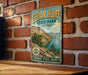 A vintage-style metal sign for Cedar Bluff State Park in Kansas, featuring a scenic landscape with a lake and mountains.