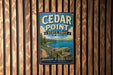A vintage metal sign for Cedar Point State Park in New York, featuring a scenic image of the park's lake and cliffs.