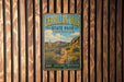 A vintage-style metal sign for Cerrillos Hills State Park in New Mexico, featuring a scenic landscape with mountains, desert vegetation, and a trail.