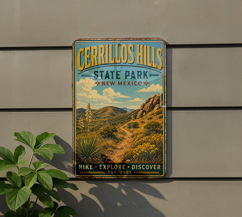 A vintage-style metal sign for Cerrillos Hills State Park in New Mexico, featuring a scenic landscape with mountains, desert vegetation, and a trail.