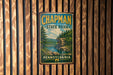 A vintage metal sign for Chapman State Park in Pennsylvania, featuring a scenic landscape with a river and forest.