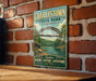 A vintage-style metal sign for Charlestown State Park in Indiana, featuring a scenic illustration of a bridge over a river surrounded by lush greenery.