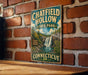 A vintage metal sign for Chatfield Hollow State Park in Connecticut, featuring a scenic illustration of a waterfall surrounded by lush greenery.