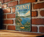 A vintage-style metal sign for Cheney State Park in Kansas, featuring a scenic illustration of a lake, mountains, and a sailboat.